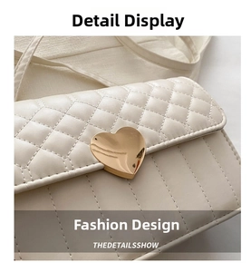 Detail of a beige quilted shoulder bag featuring a gold heart-shaped metal buckle clasp