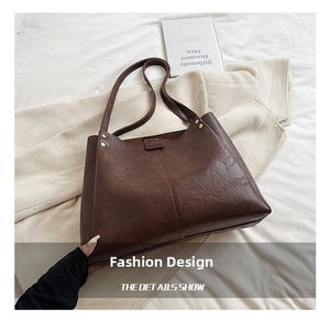 Détail du cabas en cuir marron foncé avec fermeture magnétique et logo embossé