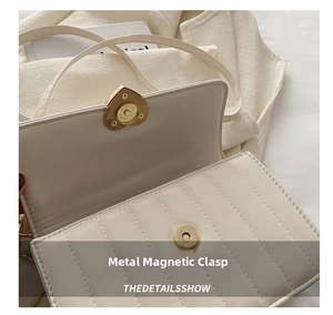 Detail of elegant gold heart-shaped magnetic closure on a quilted beige shoulder bag