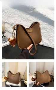 Detail of brown faux leather shoulder bag featuring a fashion hardware and lion plush charm