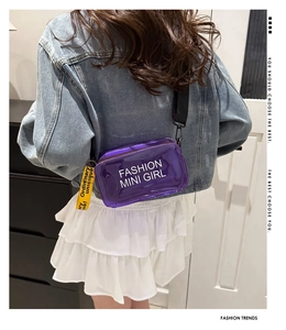 Detail of purple jelly crossbody bag featuring fashion mini girl print and strap