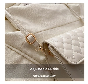Detail of adjustable shoulder strap with gold-tone hardware on quilted crossbody bag