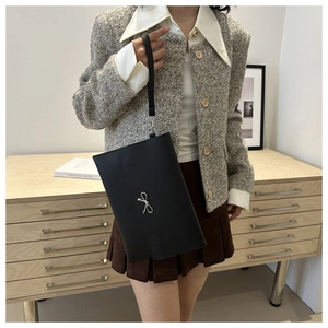 Slim black leather clutch bag with silver bow detail and wristlet strap for women