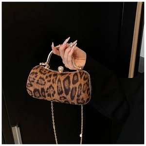 Macro shot of leopard print evening clutch with gold metal handle and diamond-encrusted clasp