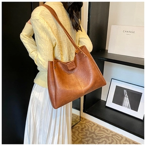 Détail de la texture cuir marron et de l'étiquette mode sur le sac cabas