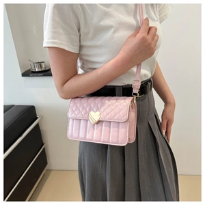 Close-up of pink quilted leather bag with elegant gold heart-shaped metal lock detail