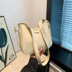 Fashionable cream half-moon underarm bag with gold metal buckle and wide strap