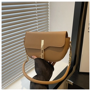 Detail of light brown saddle bag with pebble leather texture and gold hardware clasp