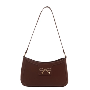 Retro brown leather underarm bag with gold bow ornament on a clean white background