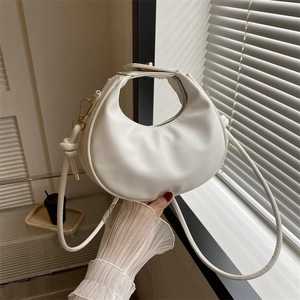 Chic white crescent handbag in PU leather with gold hardware and knotted strap detail