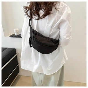 Détail d'un sac banane noir en nylon avec double fermeture éclair et tirettes en corde