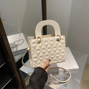 Chic cream quilted crossbody handbag with triangular stitching and gold metal hardware