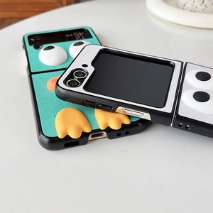 Close-up of folding phone case with 3D cartoon duck eyes and feet on textured leather