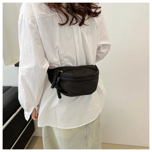 Dettaglio borsa a tracolla in tela nera con cerniera in corda decorativa su camicia