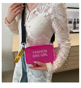 Détail du mini sac gelée fuchsia avec texte mode blanc et bandoulière large colorée