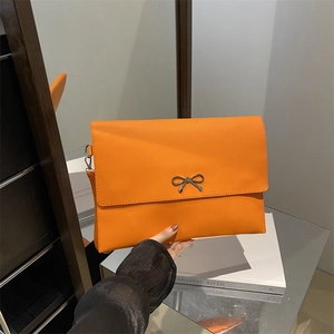 Bright orange envelope handbag with silver bow detail and smooth faux leather finish