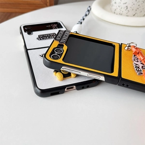Detail of leather texture Z Flip phone case with bear ornament and checkered lanyard