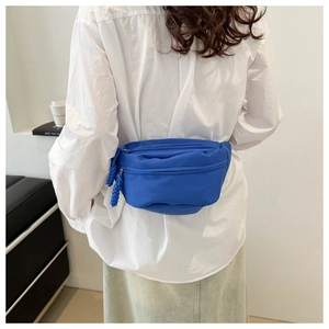 Royal blue canvas waist bag with zipper cords shown on model back over a white shirt
