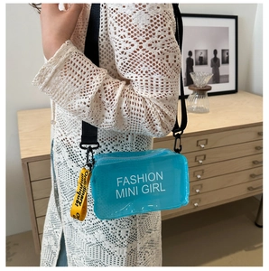 Detail of blue mini crossbody bag with fashion print and yellow decorative strap