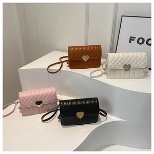 Four quilted crossbody bags in various colors with golden heart-shaped locks on white pedestals