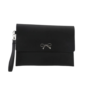 Minimalist black envelope clutch bag featuring a silver metal bow and wristlet strap
