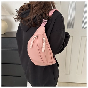 Pink sporty chest bag on model's back with woven zipper pull and adjustable strap