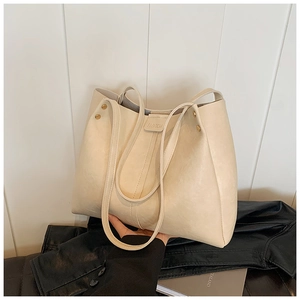 Détails d'un grand sac cabas beige avec rivets dorés et sangle embossée FASHION