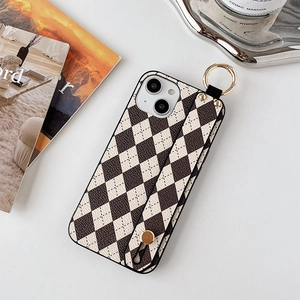 Détail de coque iPhone 16 Pro Max en cuir à losanges noir et blanc avec dragonne intégrée