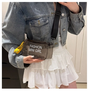 Détail du sac à bandoulière en PVC gris transparent avec sangle jaune et logo mode