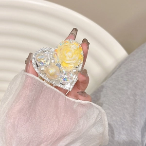 Macro shot of a heart-shaped phone grip with yellow resin rose and pearls