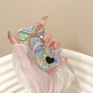 Glittering heart-shaped phone grip with floating sequins and gold bow decorative detail