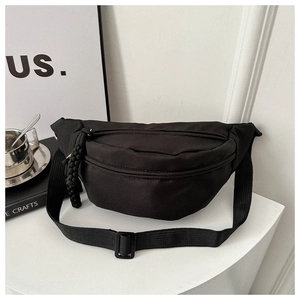 Close-up of black nylon waist bag with unique woven knot zipper pulls and adjustable strap