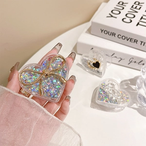 Detail showing heart-shaped phone grip with glitter, sequins and bow decoration