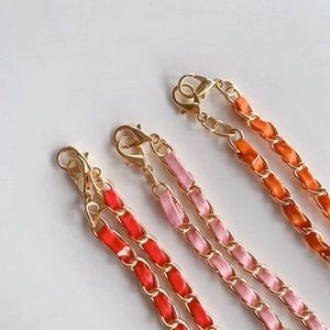 Detail of crossbody phone chain with gold metal and colorful leather strap options