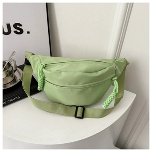 Close-up of avocado green nylon waist bag featuring durable zippers and woven pull tabs