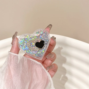 Close-up of heart-shaped phone grip with glitter sand and gold rhinestone heart detail