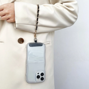 Detail of gold metal and black leather woven chain strap on a clear wave edge phone case