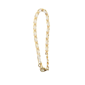 Detail of woven gold metal chain with white leather and lobster clasp closure