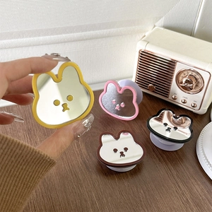 Cute bunny mirror phone sockets in yellow, pink, brown, and black colors on wooden desk
