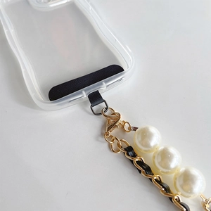 Detail of elegant pearl and gold metal chain strap on clear wavy phone case