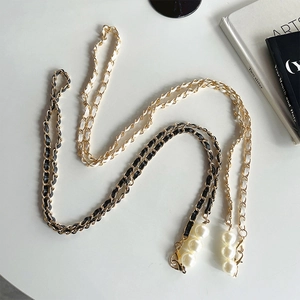 Detail of luxury pearl crossbody phone chains with gold metal and black white leather straps