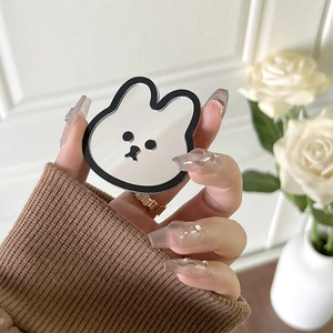 Close-up of rabbit-shaped acrylic phone grip mirror held by hand in home setting
