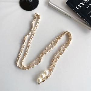 Detail of woven leather gold chain with pearl accents for bags and mobile phones