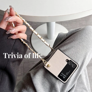 Detail of white lychee leather folding phone case with elegant gold metal chain strap