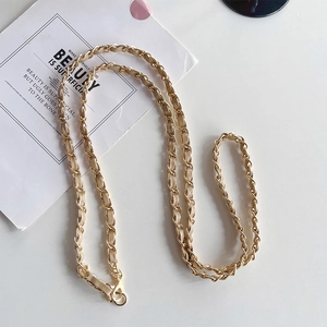 Detail view of woven gold chain strap with cream leather for bags and phone cases