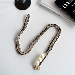 Detail of gold metal and black leather woven strap with three large pearls and lobster clasp