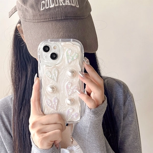 Coque iPhone texture crème 3D avec cœurs laser et perles tenue par un modèle