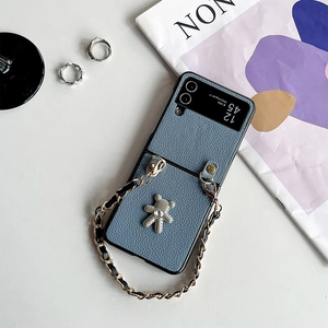 Detailed blue litchi leather folding phone case with metal woven chain and diamond bear charm