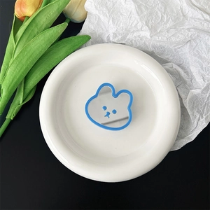 Close-up of cute blue bear mirror phone grip on white tray with decorative tulips