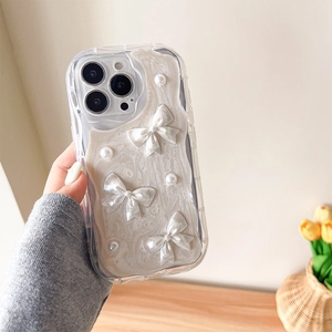 Détail montrant les nœuds 3D et perles sur une coque iPhone couleur crème